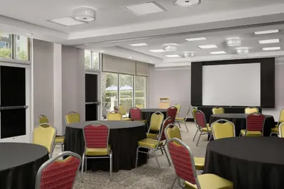 a conference room with tables and chairs and a white screen at Hampton Inn & Suites Orlando North Altamonte Springs in Orlando