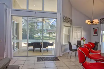 a living room with a pool table and red chairs at 5 Bedroom 3 and half Bathroom Luxury Villa at Windsor Palms in Kissimmee