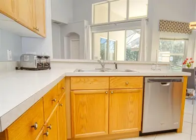 a kitchen with wooden cabinets and a sink at 5 Bedroom 3 and half Bathroom Luxury Villa at Windsor Palms in Kissimmee