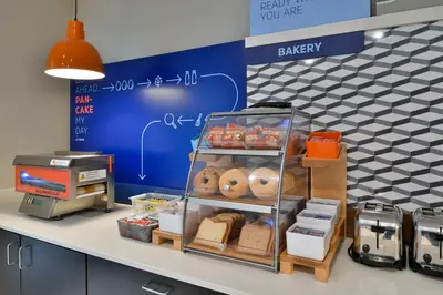 a bakery with a shelf with food on a counter at Holiday Inn Express Orlando - South Park by IHG in Orlando