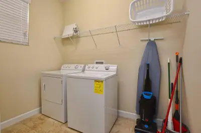 a laundry room with a washing machine and a shelf at Sunny Escape, Pool, Spa, Resort-3509Pp in Kissimmee