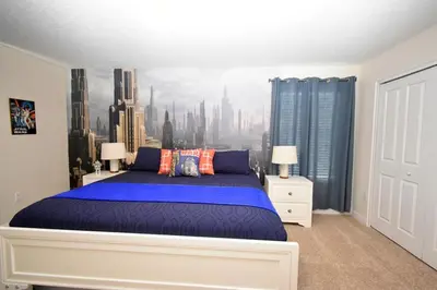 a bedroom with a large bed with a city mural on the wall at Luxury Pool Home, Spa, Grill- 1664St in Kissimmee