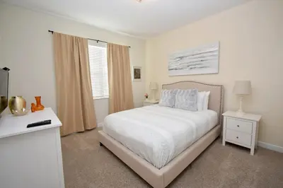 a white bedroom with a bed and a window at Luxury Pool Home, Spa, Grill- 1664St in Kissimmee