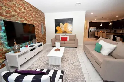 a living room with a couch and a tv at Luxury Pool Home, Spa, Grill- 1664St in Kissimmee