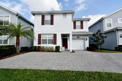 a white house with a palm tree and a driveway at Luxury Pool Home, Spa, Grill- 1664St in Kissimmee