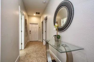 a hallway with a glass table and a mirror at Dog Friendly Townhome Wsplashpool- 1600St in Kissimmee