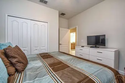 a bedroom with a bed and a flat screen tv at Dog Friendly Townhome Wsplashpool- 1600St in Kissimmee