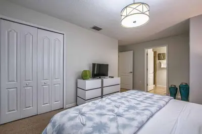 a bedroom with a large bed and a television at Dog Friendly Townhome Wsplashpool- 1600St in Kissimmee