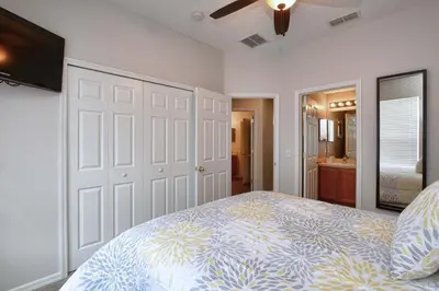 a bedroom with a large bed and a bathroom at Serene Pool & Spa, Gated Resort- 2201Em in Kissimmee