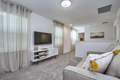 a living room with a couch and a flat screen tv at 5 Bedrooms Townhome W- Splashpool - 8205Sa in Orlando