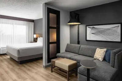 a hotel room with a couch and a bed at Hyatt Place Orlando Airport in Orlando