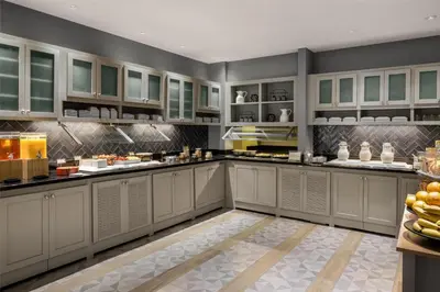a large kitchen with white cabinets and fruits on the counter at Hyatt Place Orlando Airport in Orlando