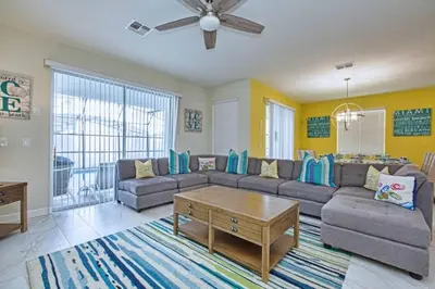 a living room with a couch and a table at Comfortable Spacious-6 Bed Pool Home - 1675Str in Kissimmee