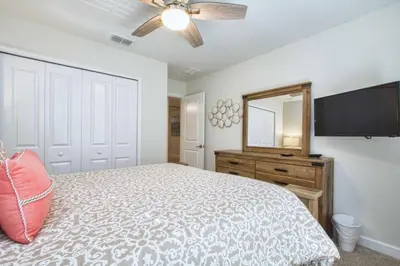 a bedroom with a bed and a dresser and a mirror at Comfortable Spacious-6 Bed Pool Home - 1675Str in Kissimmee