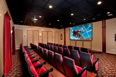 a cinema room with red chairs and a large screen at Pool Home With Privacy, Bbq, Mickey Room - 3500Pp in Kissimmee