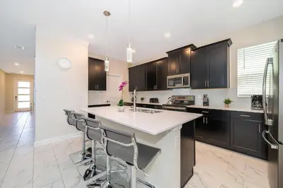 a kitchen with black cabinets and a white counter top at 2769RP VILLA 5 BED/5 BA (SANITIZED) in Kissimmee