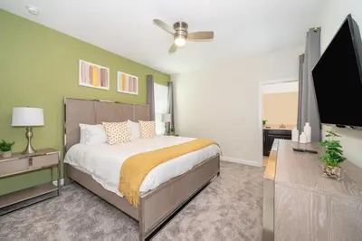 a bedroom with a bed and a flat screen tv at 2769RP VILLA 5 BED/5 BA (SANITIZED) in Kissimmee