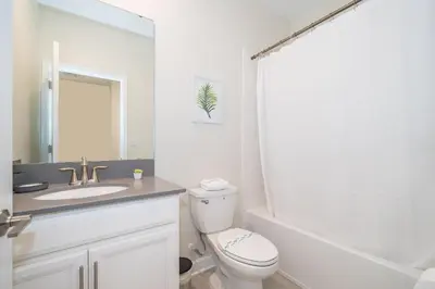 a bathroom with a toilet and a sink and a bathtub at 2764SG VILLA 5 BED/5 BA (SANITIZED) in Kissimmee