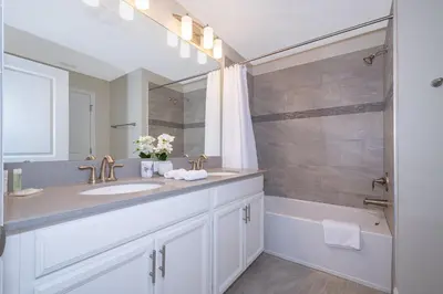 a white bathroom with a sink and a tub at 4809AM TOWNHOUSE 4 BEDROOMS & 3 BATHROOMS + POOL in Kissimmee