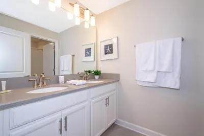 a bathroom with a sink and a large mirror at 4809AM TOWNHOUSE 4 BEDROOMS & 3 BATHROOMS + POOL in Kissimmee