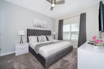 a white bedroom with a large bed and a window at 4313SL TOWNHOUSE 4 BEDROOMS & 3 BATHROOMS + POOL in Kissimmee