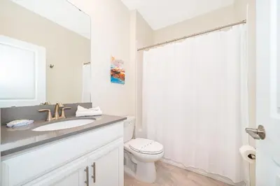 a white bathroom with a sink and a toilet at 4352JP VILLA 5 BED/5 BA in Kissimmee