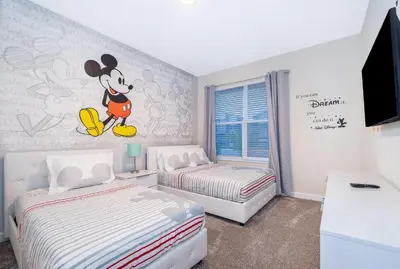 a bedroom with two beds and a mickey mouse mural at 4352JP VILLA 5 BED/5 BA in Kissimmee