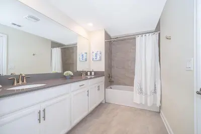 a bathroom with a sink and a tub and a shower at 4393MO TOWNHOUSE 5 BEDROOMS & 4 BATHROOMS + POOL in Kissimmee