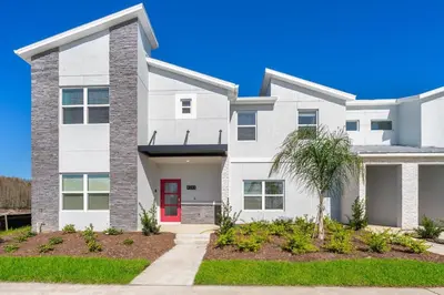 a white house with a red door at 4393MO TOWNHOUSE 5 BEDROOMS & 4 BATHROOMS + POOL in Kissimmee