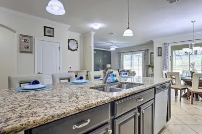 a kitchen with a sink and a living room at Paradise Palms Home with Pool, 6 Mi to Disney! in Kissimmee