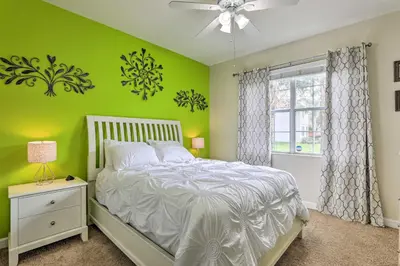 a green bedroom with a bed and a window at Paradise Palms Home with Pool, 6 Mi to Disney! in Kissimmee