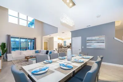 a dining room and living room with a table and chairs at 2811AS VILLA 5 BED/5 BA (SANITIZED) in Kissimmee