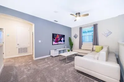a living room with a white couch and a ceiling fan at 2811AS VILLA 5 BED/5 BA (SANITIZED) in Kissimmee