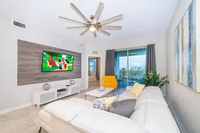 a living room with a white couch and a tv at 3150-308BR STOREY LAKE, CONDO 3/2 POOL VIEW in Kissimmee