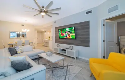 a living room with a couch and a tv on a wall at 3150-308BR STOREY LAKE, CONDO 3/2 POOL VIEW in Kissimmee