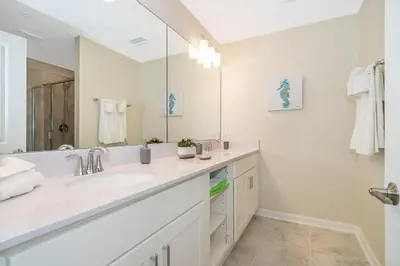 a bathroom with a sink and a large mirror at 3150-308BR STOREY LAKE, CONDO 3/2 POOL VIEW in Kissimmee
