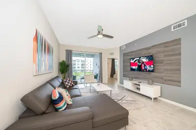 a living room with a couch and a flat screen tv at 3180-201JB STOREY LAKE, CONDO 3/2 GARDEN VIEW in Kissimmee
