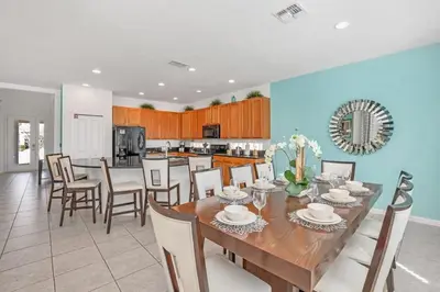 a dining room and kitchen with a table and chairs at Stunning LAKE VIEW, Big Pool Area with CDC Standards #6BV507 in Kissimmee
