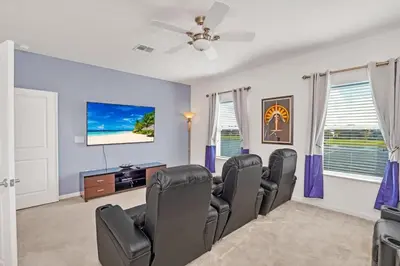 a living room with chairs and a flat screen tv at Stunning LAKE VIEW, Big Pool Area with CDC Standards #6BV507 in Kissimmee