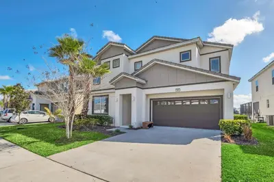 a large white house with a garage at Stunning LAKE VIEW, Big Pool Area with CDC Standards #6BV507 in Kissimmee