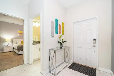 a hallway with a white door and a bedroom at 3151LS TOWNHOUSE 4 BEDROOMS & 3 BATHROOMS + POOL in Kissimmee