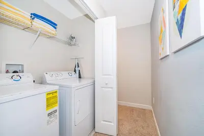 a white laundry room with a washer and dryer at 3151LS TOWNHOUSE 4 BEDROOMS & 3 BATHROOMS + POOL in Kissimmee
