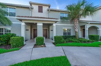 a house with a palm tree in front of it at 3151LS TOWNHOUSE 4 BEDROOMS & 3 BATHROOMS + POOL in Kissimmee