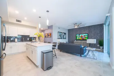 a kitchen and living room with a couch and a tv at 3180-103EF STOREY LAKE, CONDO 2/2 GARDEN VIEW in Kissimmee