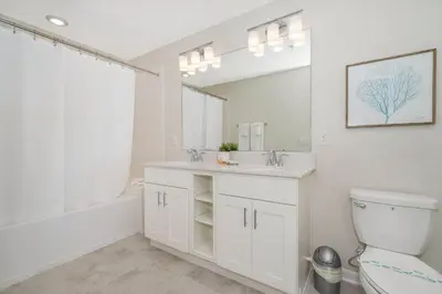 a white bathroom with a sink and a toilet at 3180-305MN STOREY LAKE, CONDO 2/2 POOL VIEW in Kissimmee