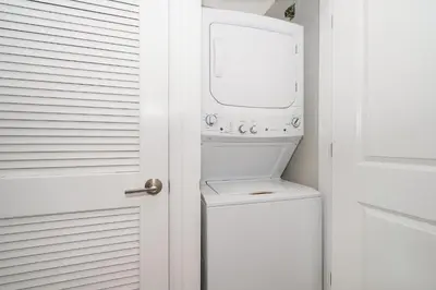a white laundry room with a washer and dryer at 3180-305MN STOREY LAKE, CONDO 2/2 POOL VIEW in Kissimmee