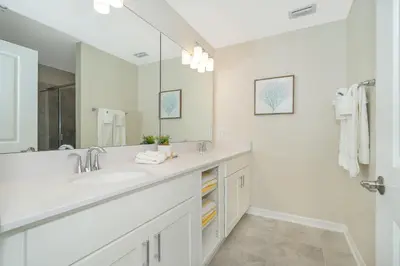 a white bathroom with a sink and a mirror at 3180-305MN STOREY LAKE, CONDO 2/2 POOL VIEW in Kissimmee