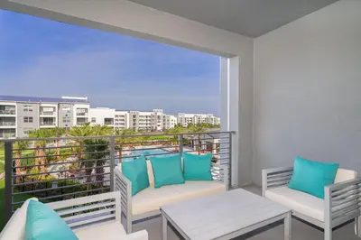 a balcony with two chairs and a table and a window at 3180-305MN STOREY LAKE, CONDO 2/2 POOL VIEW in Kissimmee