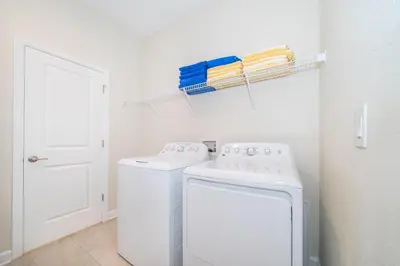 a white laundry room with a washer and dryer at 2825PA VILLA 5 BED/5 BA (SANITIZED) in Kissimmee