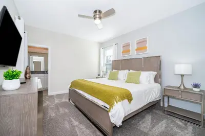 a bedroom with a bed and a flat screen tv at 2825PA VILLA 5 BED/5 BA (SANITIZED) in Kissimmee